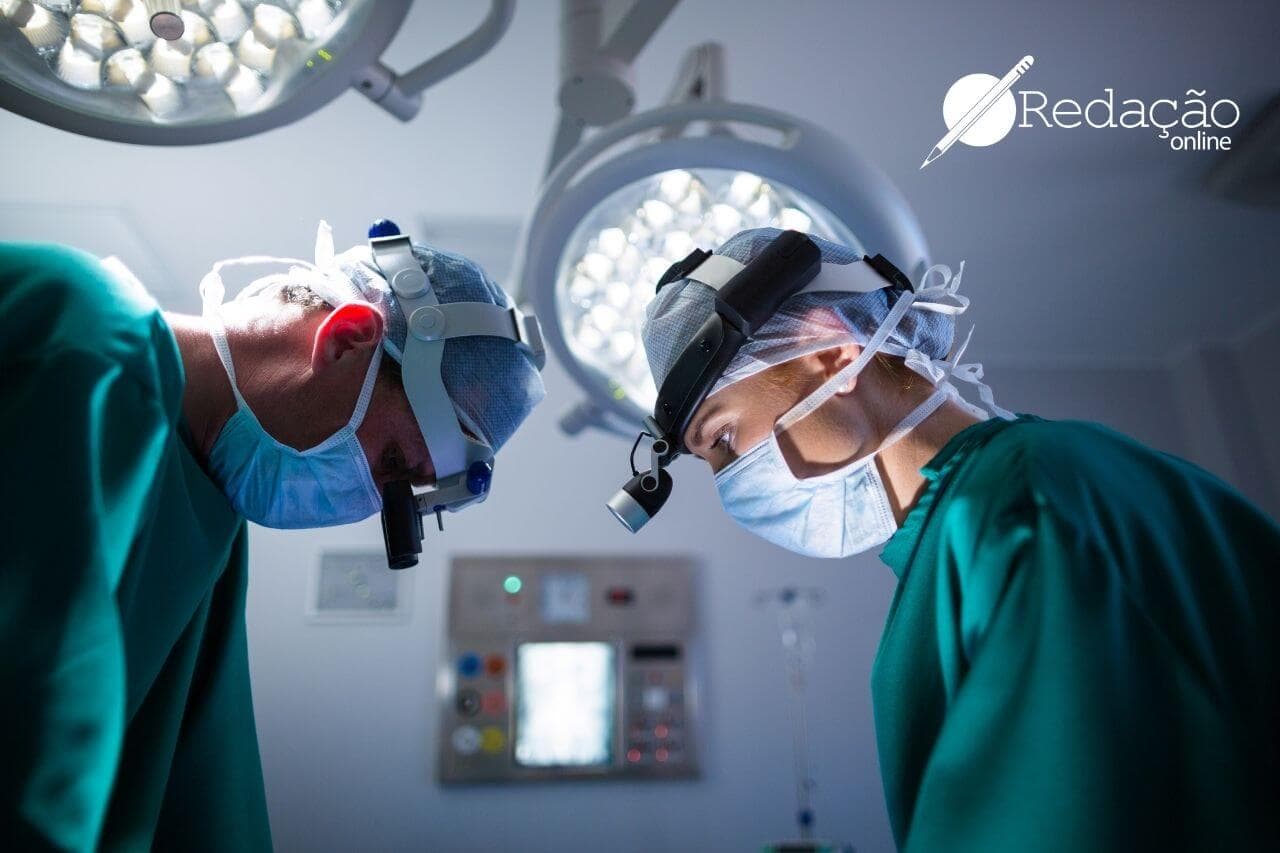dois médicos fazendo cirurgia com jaleco verde